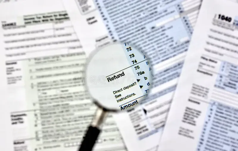 magnifying glass hovering over a detailed tax form with highlighted deductions