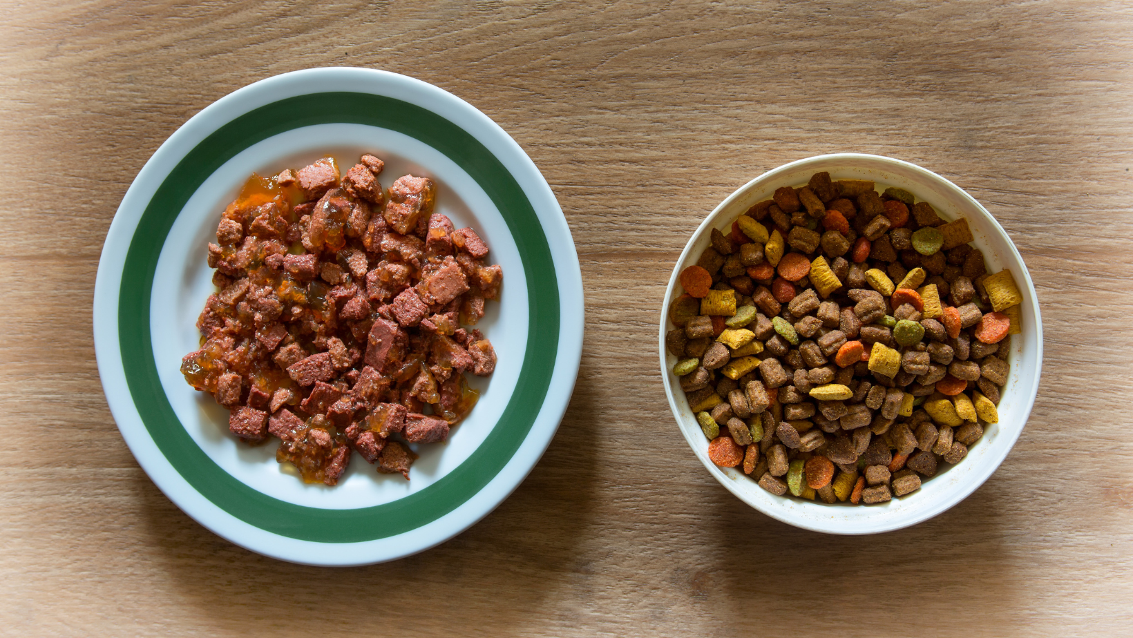 Bowls of wet and dry cat food, side-by-side on a table.