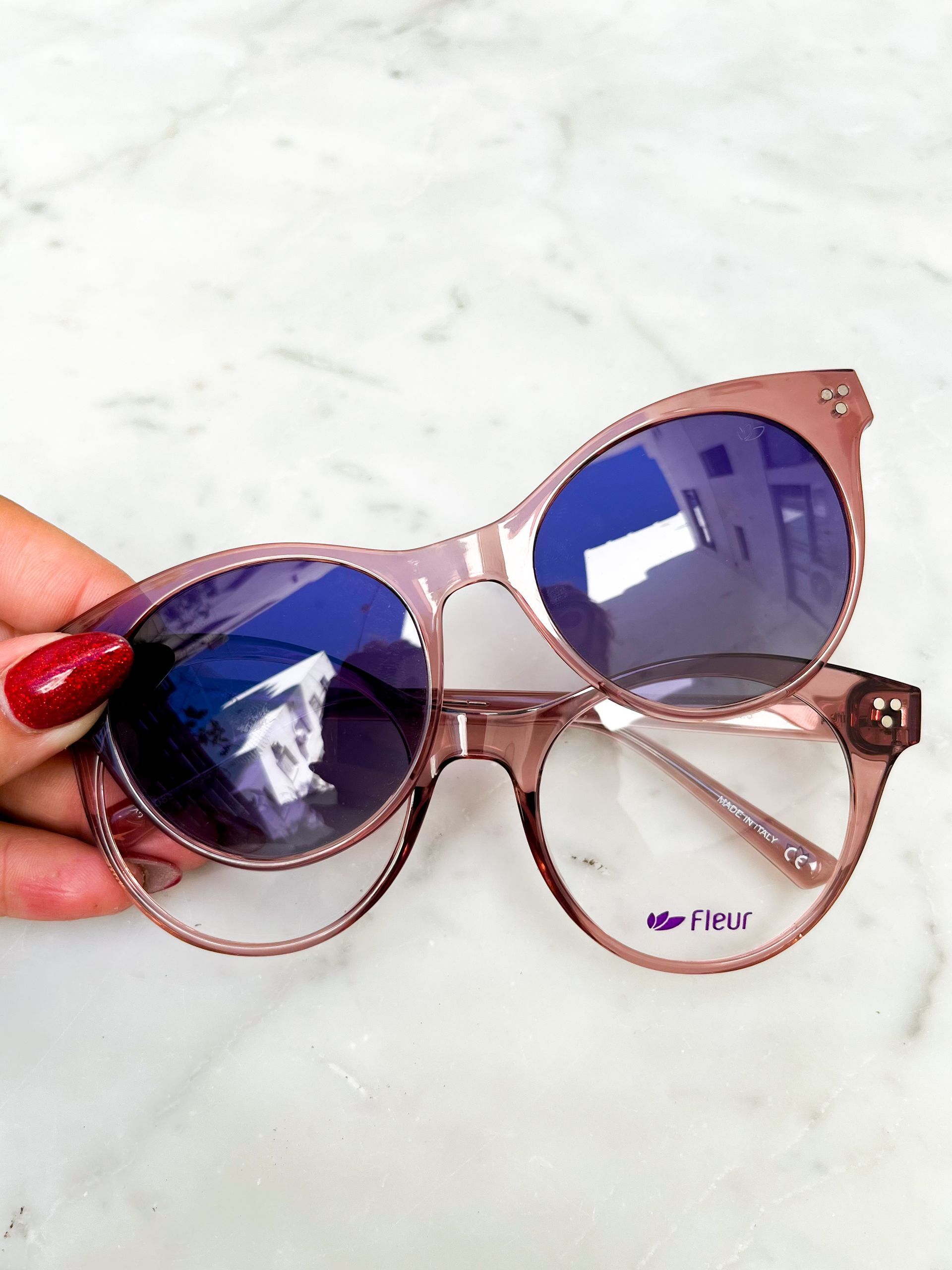 Montura de gafas de sol de color negro con lente tintada con clip, colocada sobre gafas con lentes transparentes