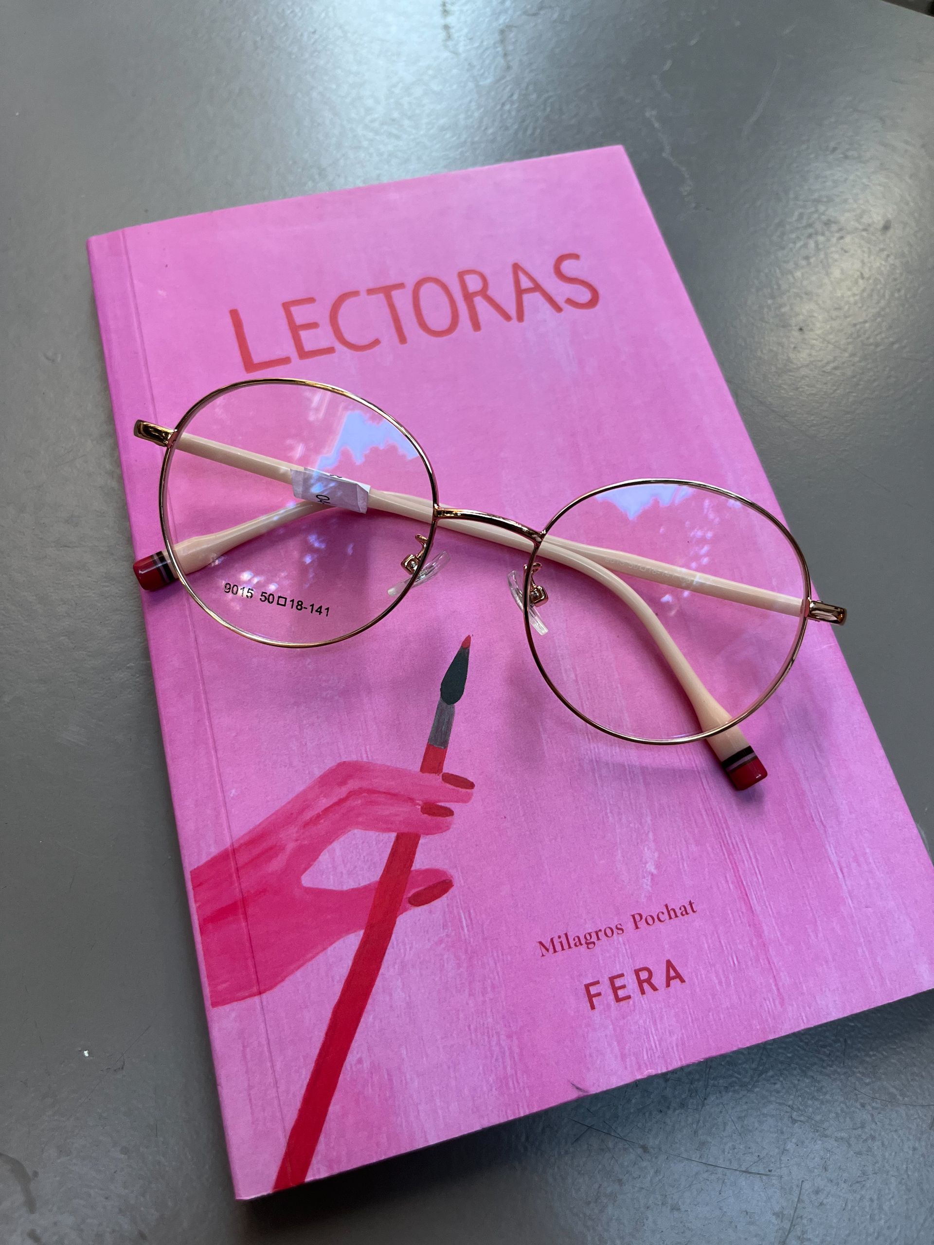 Vasos redondos descansan sobre un libro rosa titulado 