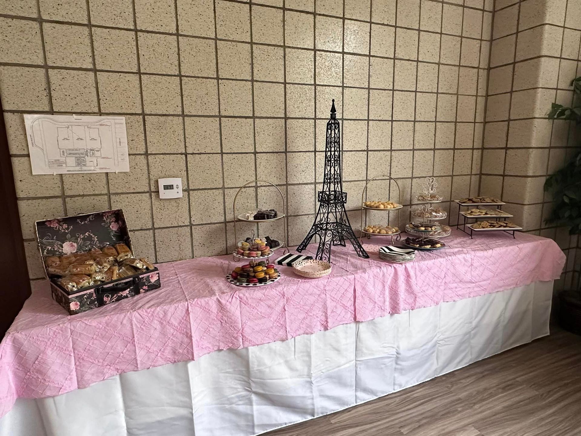 An array of cookies and other sweets on a pink tablecloth.