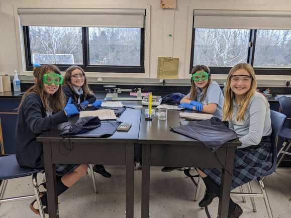 A group of girls from Immaculate Conception Catholic School in Ira Township, MI, sitting at a table in a lab.
