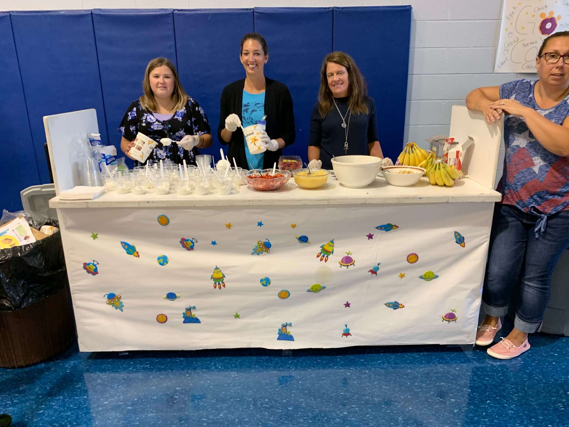 A group of women standing around a table with food on it