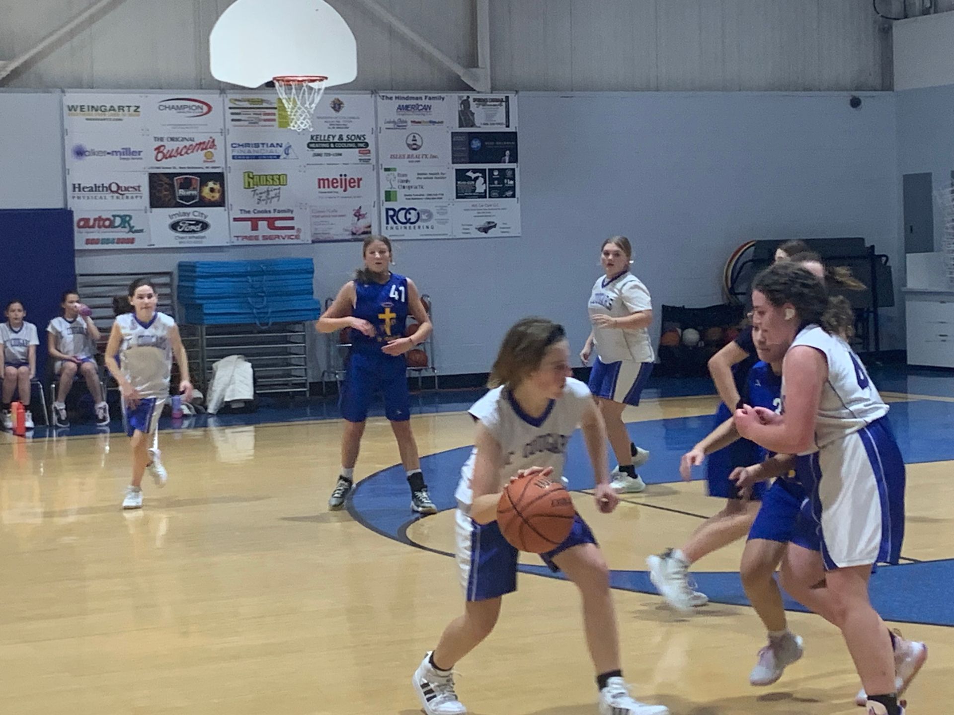 Two teams of girls are playing basketball.
