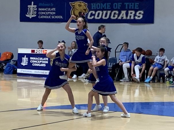 A group of cheerleaders from Immaculate Conception Catholic School performing on a basketball court in Ira Township.
