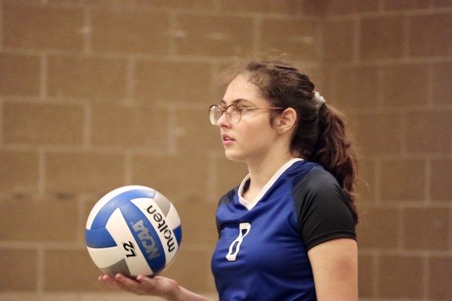 A girl from MI, Immaculate Conception Catholic School, holding a volleyball ball.