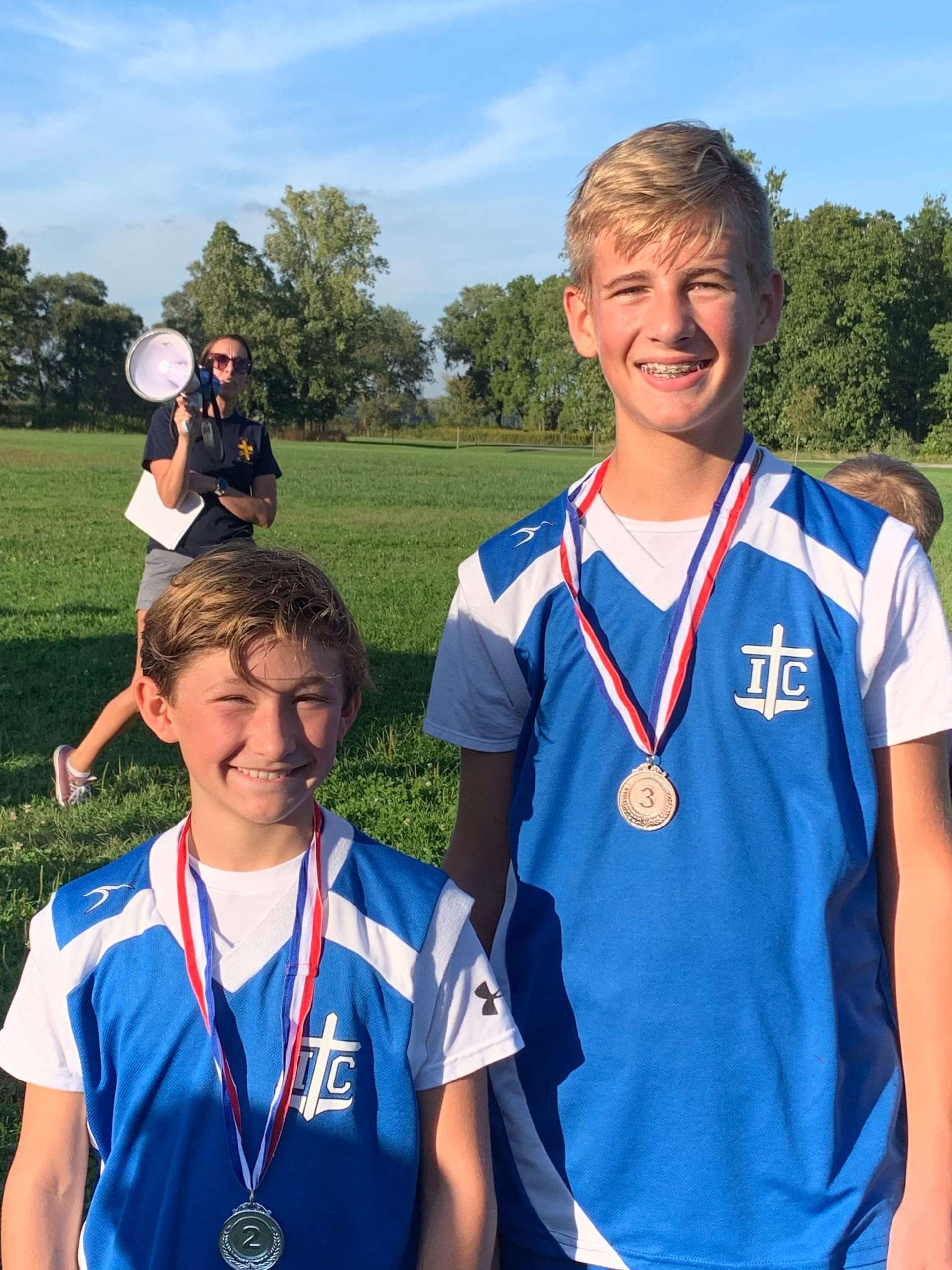 Two boys with I.C. jerseys and medals pose for a picture.