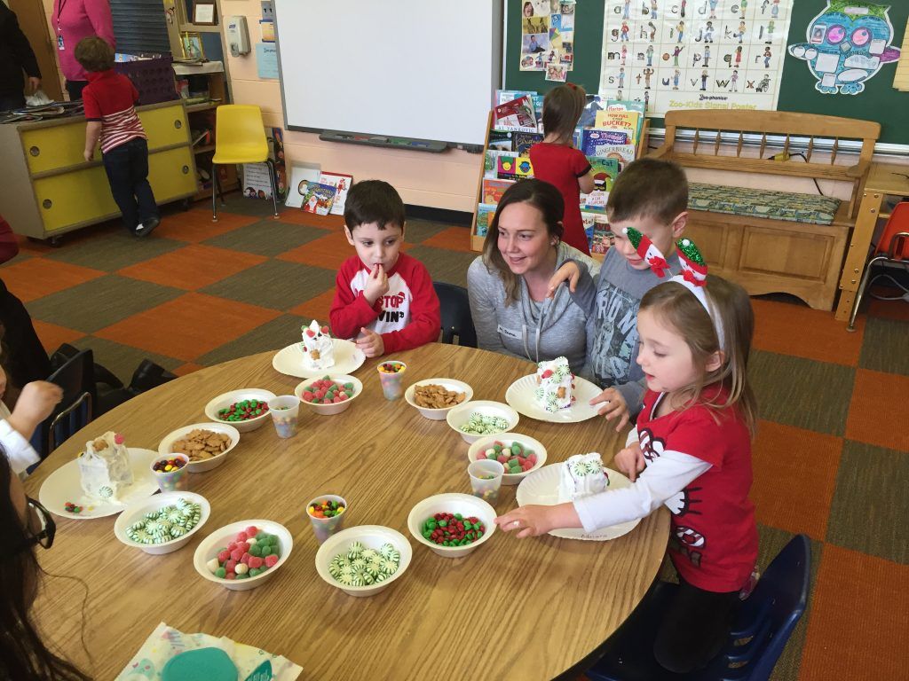 A group of children are sitting around a table with bowls of food