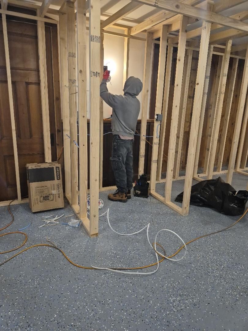 A man is standing in a room with wooden beams.