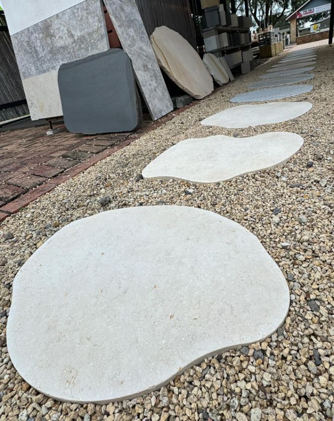 A Row Of White Stepping Stones On A Gravel Path — Premier Bricks, Blocks & Pavers In Heatherbrae, NSW