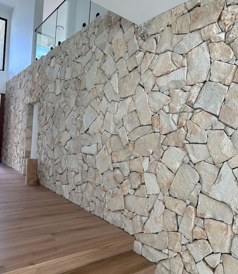 A Stone Wall In A Hallway With Wooden Floors — Premier Bricks, Blocks & Pavers In Singleton, NSW
