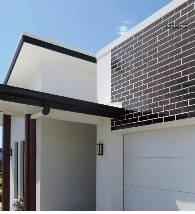 Modern white house with dark brick accent wall and black gutters — Premier Bricks, Blocks & Pavers In Heatherbrae, NSW