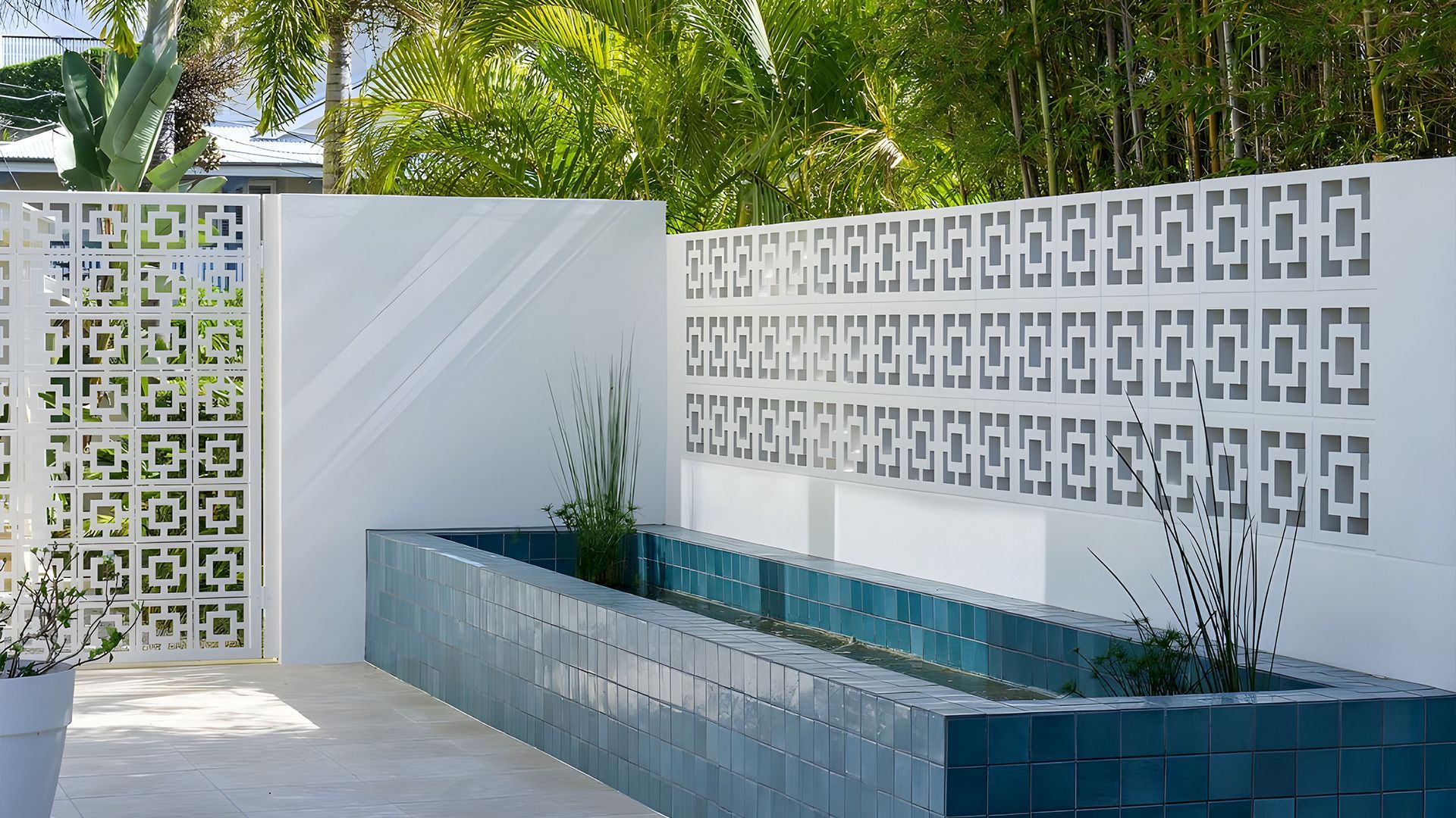 A white wall with a blue planter in front of it — Premier Bricks, Blocks & Pavers In Heatherbrae, NSW