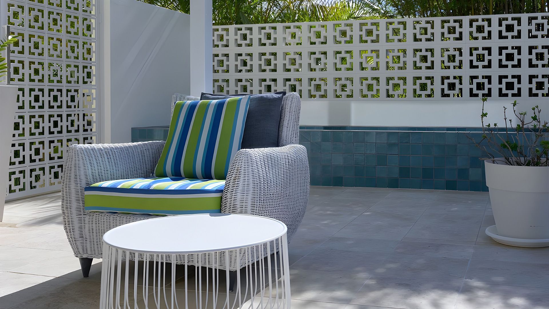 A patio with a wicker chair and a white table — Premier Bricks, Blocks & Pavers In Heatherbrae, NSW