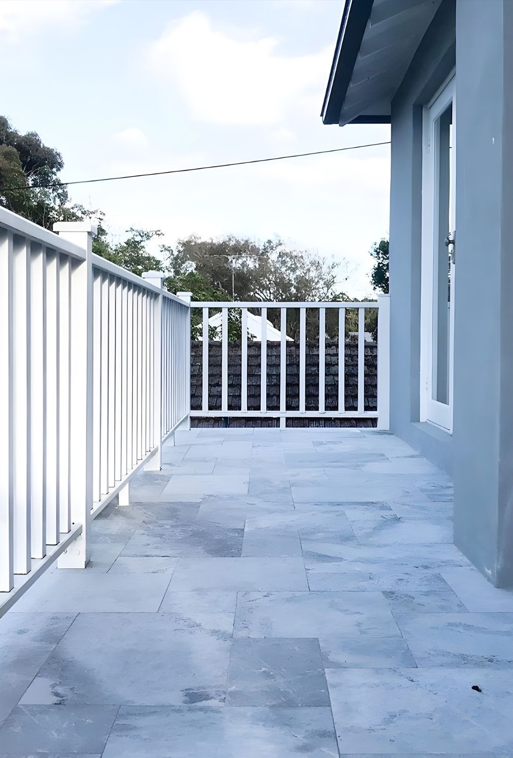 A Balcony With A White Railing On The Side Of A House — Premier Bricks, Blocks & Pavers In Newcastle, NSW