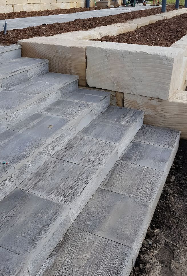 A Set Of Concrete Steps Leading Up To A Stone Wall — Premier Bricks, Blocks & Pavers In Chisholm, NSW