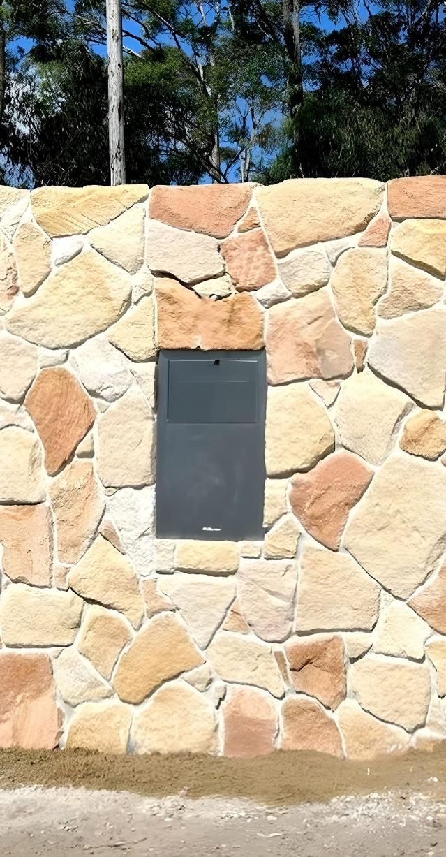 A Stone Wall With A Mailbox In The Middle Of It — Premier Bricks, Blocks & Pavers In Cessnock, NSW