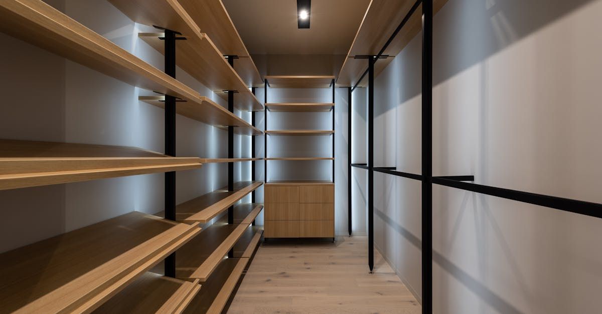 A walk in closet with lots of shelves and clothes racks.
