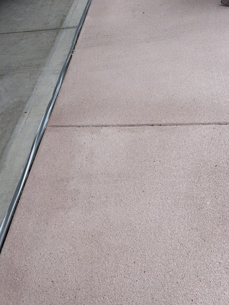 A close up of a concrete sidewalk with a metal curb.