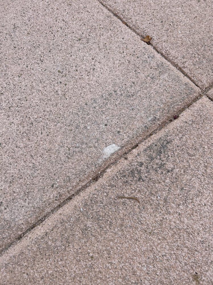 A close up of a sidewalk with a few pieces of paper on it.