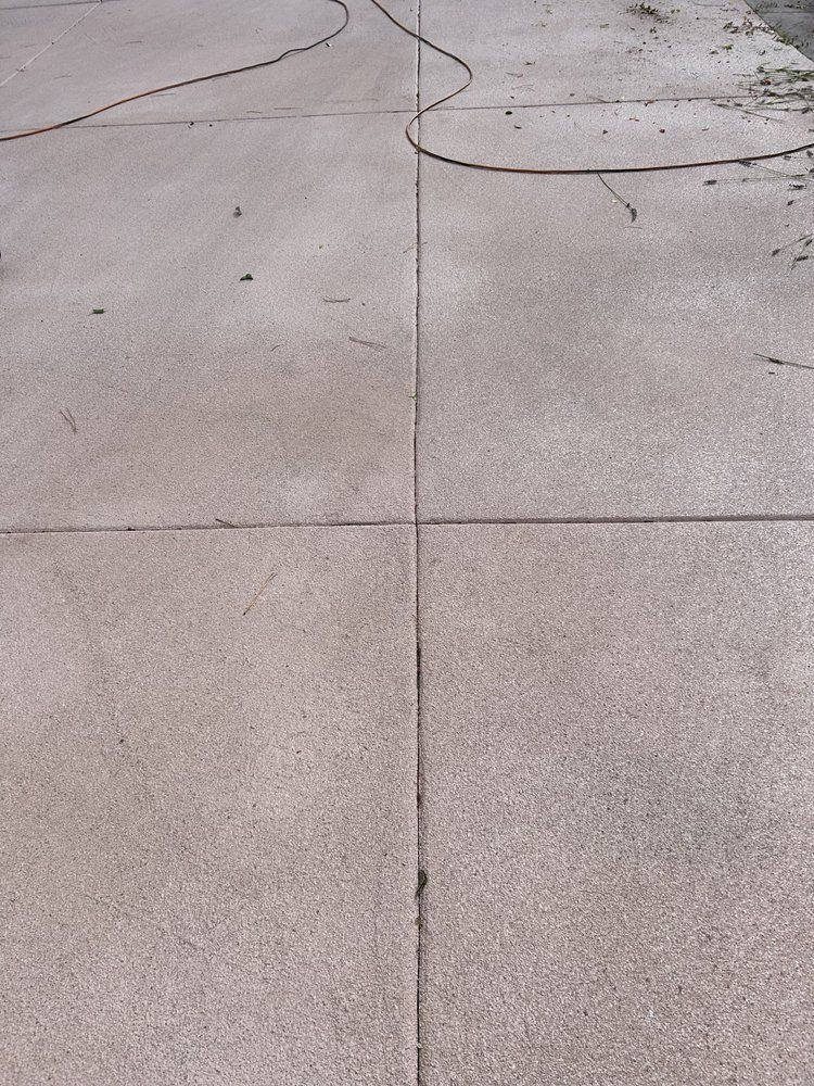 A close up of a concrete floor with a hose on it.