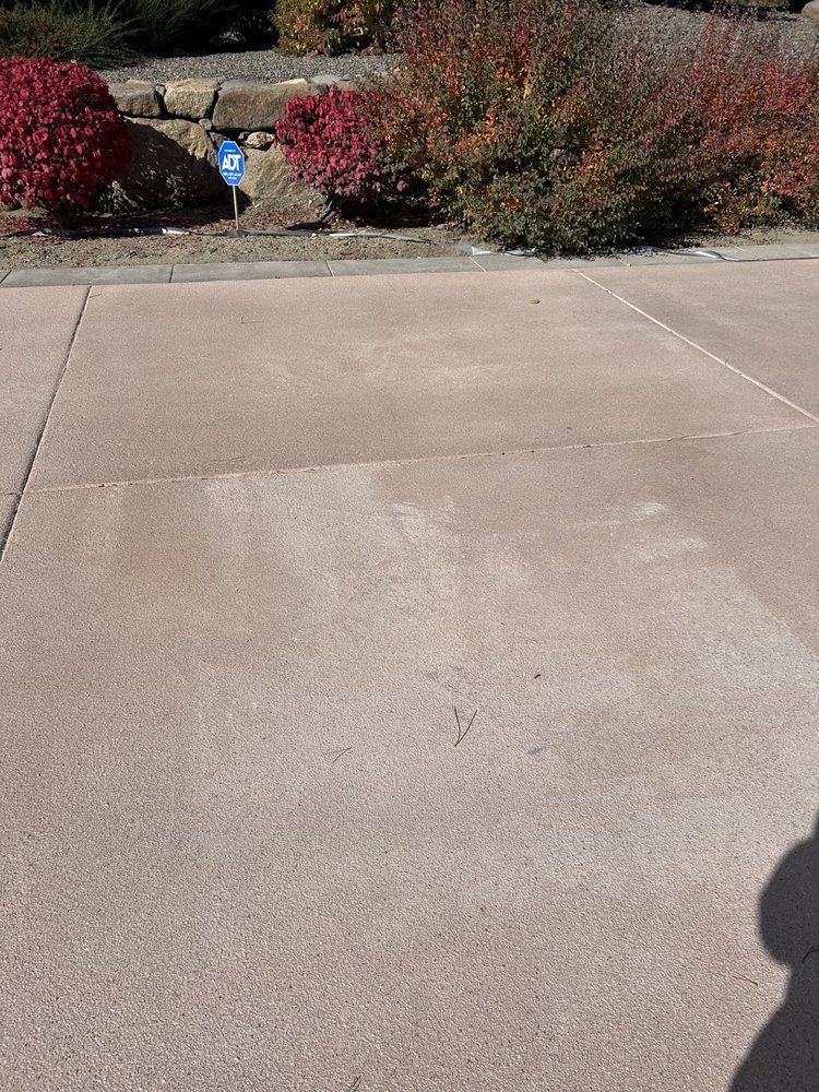 A concrete driveway with a blue sign in the background.
