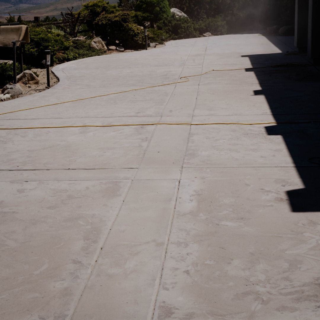 A concrete driveway with a shadow of a person on it