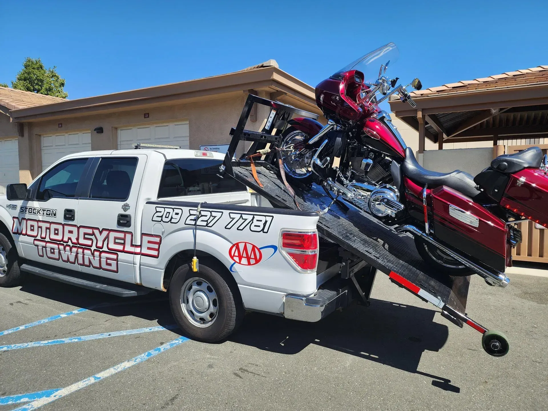 A motorcycle is being towed by a motorcycle towing truck