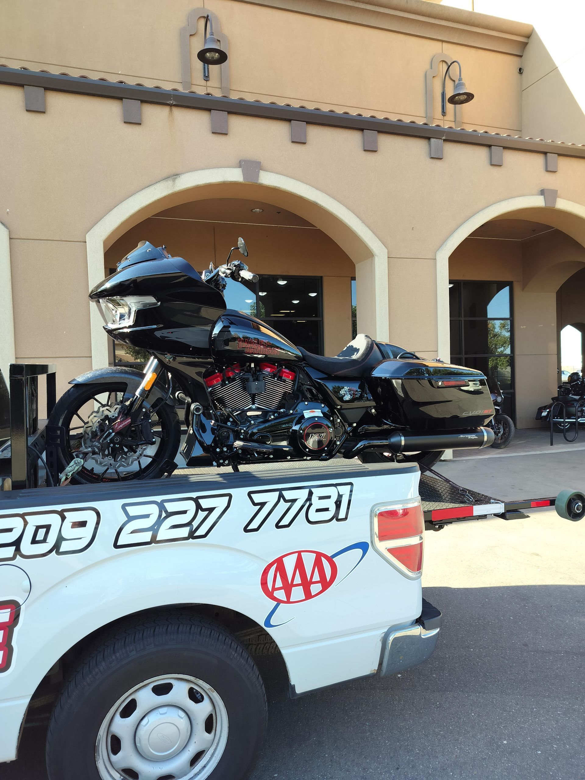 A motorcycle is in the back of a 209 227 7781 tow truck