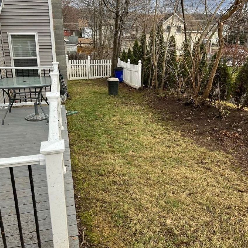 A deck with a table and chairs in the backyard of a house