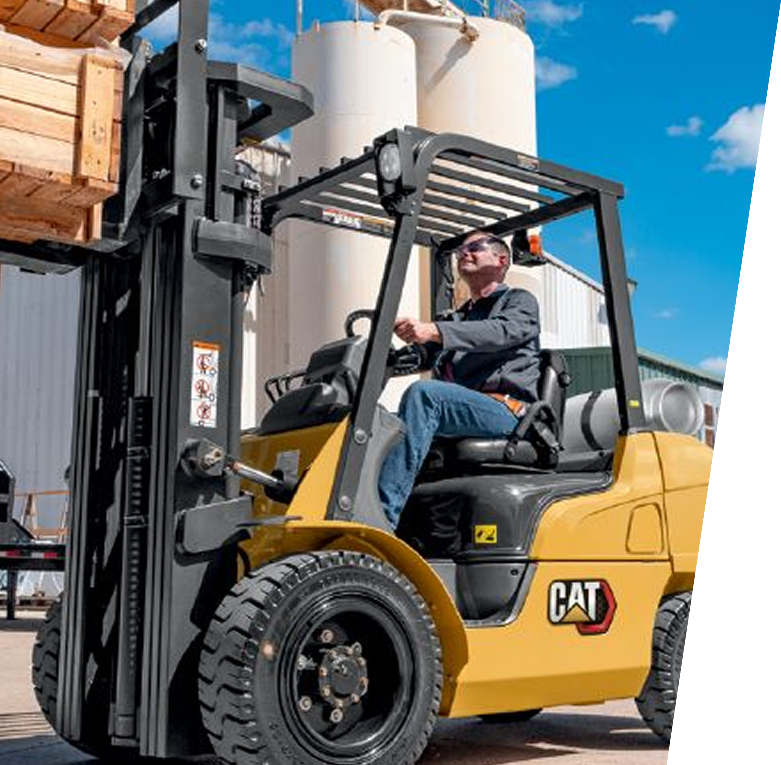 Un hombre conduce una carretilla elevadora Caterpillar amarilla al aire libre en un día soleado.