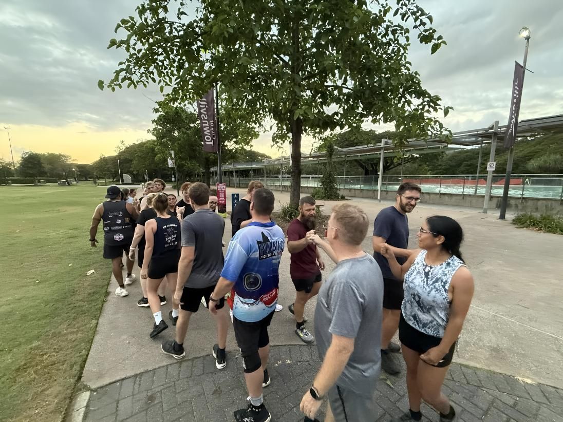 A Group Of People Are Walking Down A Sidewalk In A Park — Elev8ed Fitness In Currajong, QLD