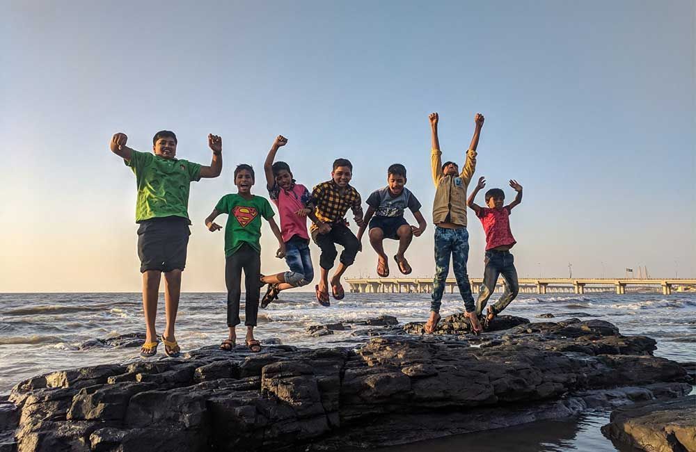 A Group Of Children Are Jumping In The Air On A Rocky Beach — Elev8ed Fitness In Currajong, QLD