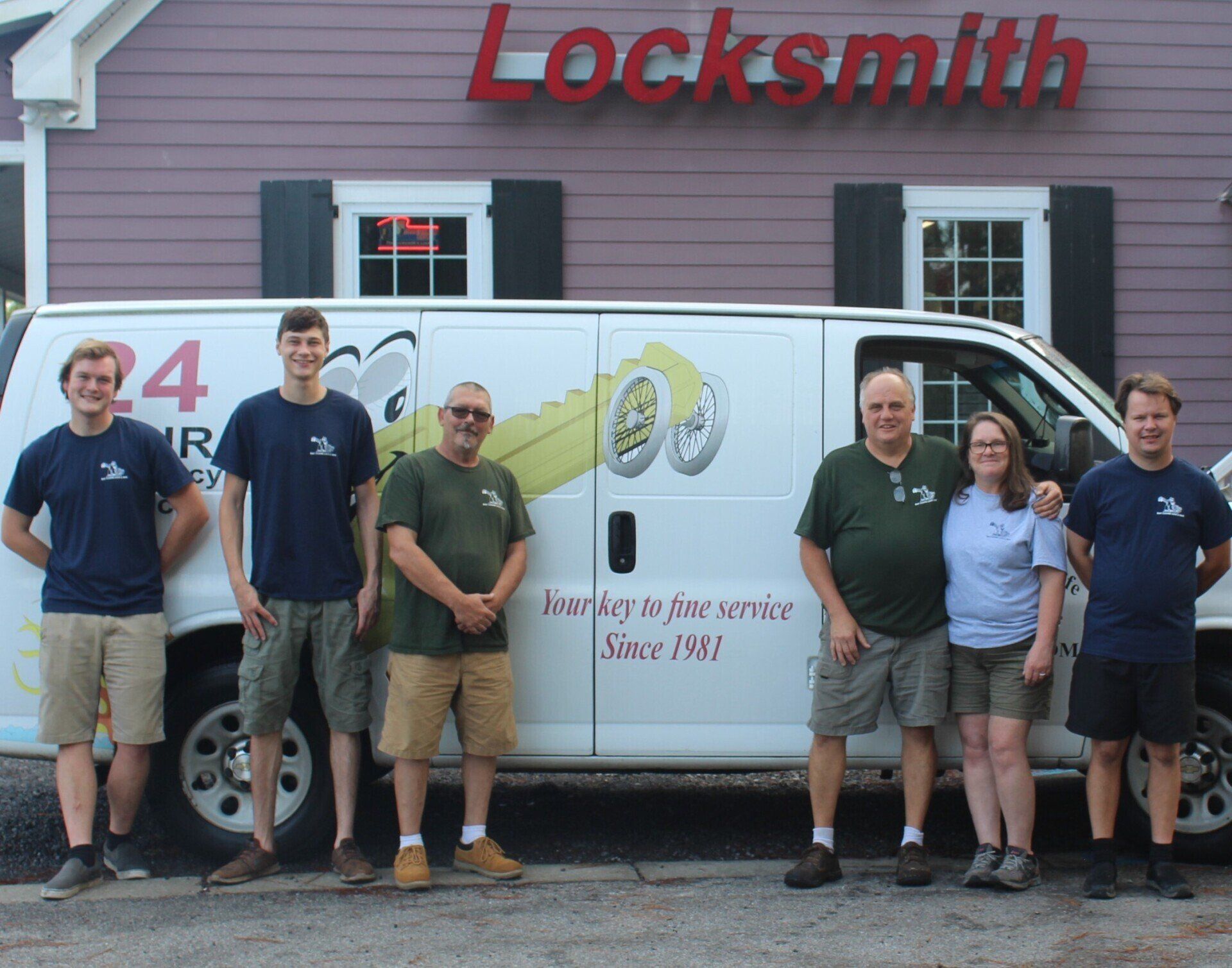 A group of people standing in front of a van that says locksmith