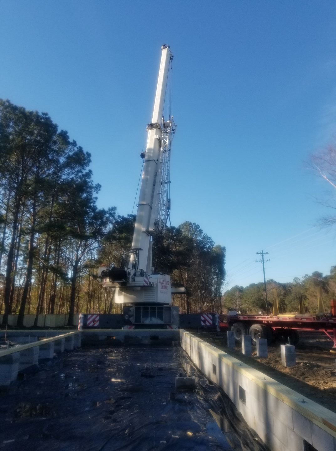 A large white crane is sitting on top of a truck.