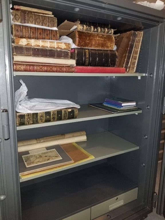 An empty safe filled with books and papers