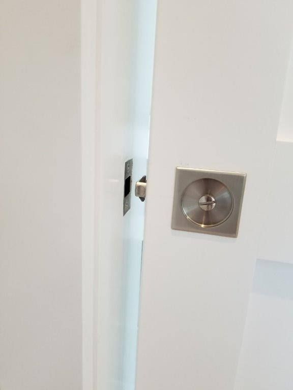 A close up of a door knob on a white door.