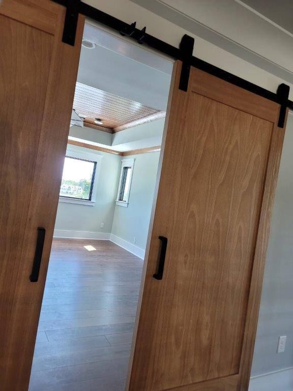 A pair of sliding barn doors open to an empty room.