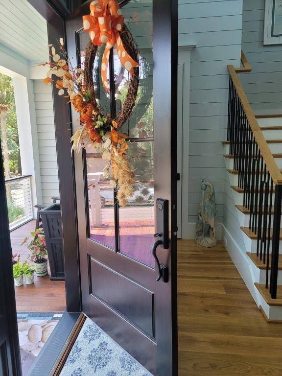 A door with a wreath on it and a staircase in the background.