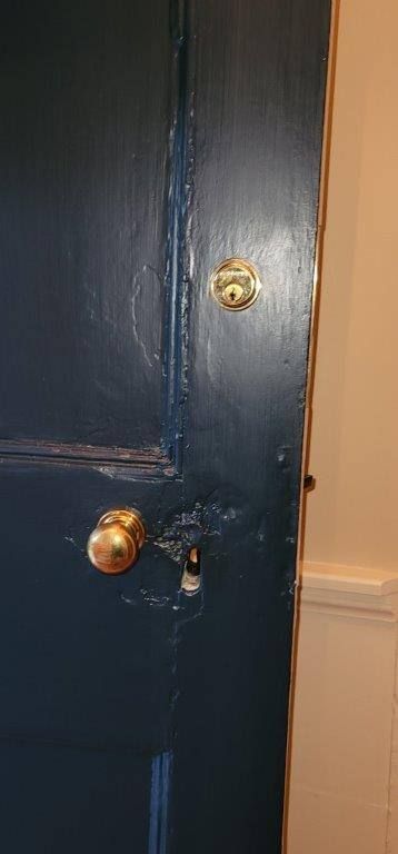A close up of a blue door with a gold door knob.