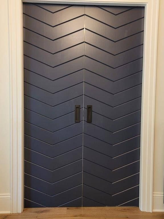 A pair of black doors with a chevron pattern on them.