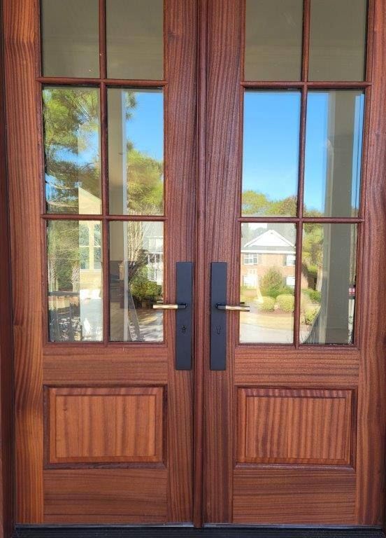 A close up of a wooden door with glass windows.