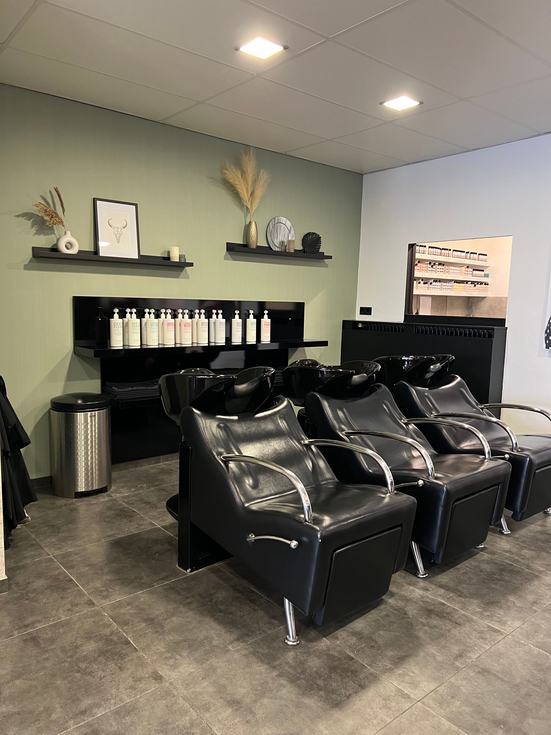 Een salon met veel stoelen en een wastafels.