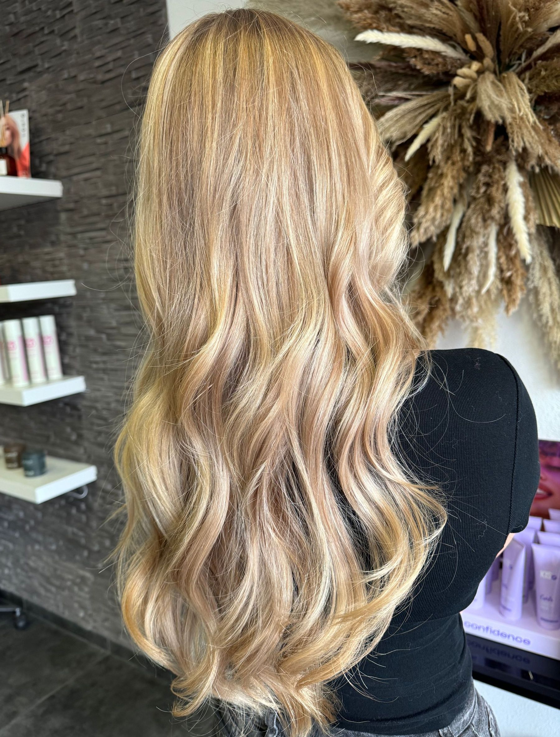 Een vrouw met lang blond haar staat in een kamer.