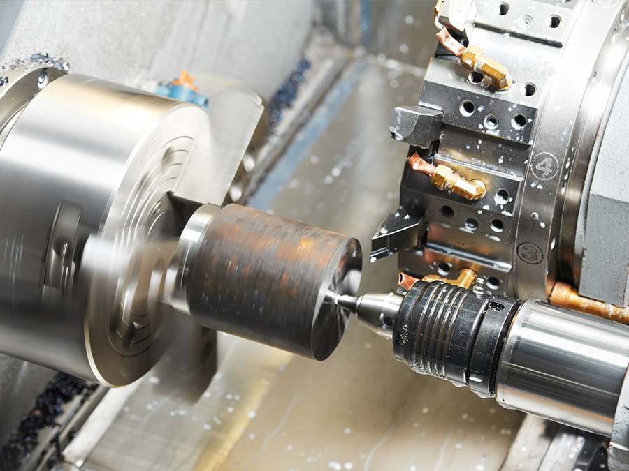 A machine is cutting a piece of metal on a lathe.