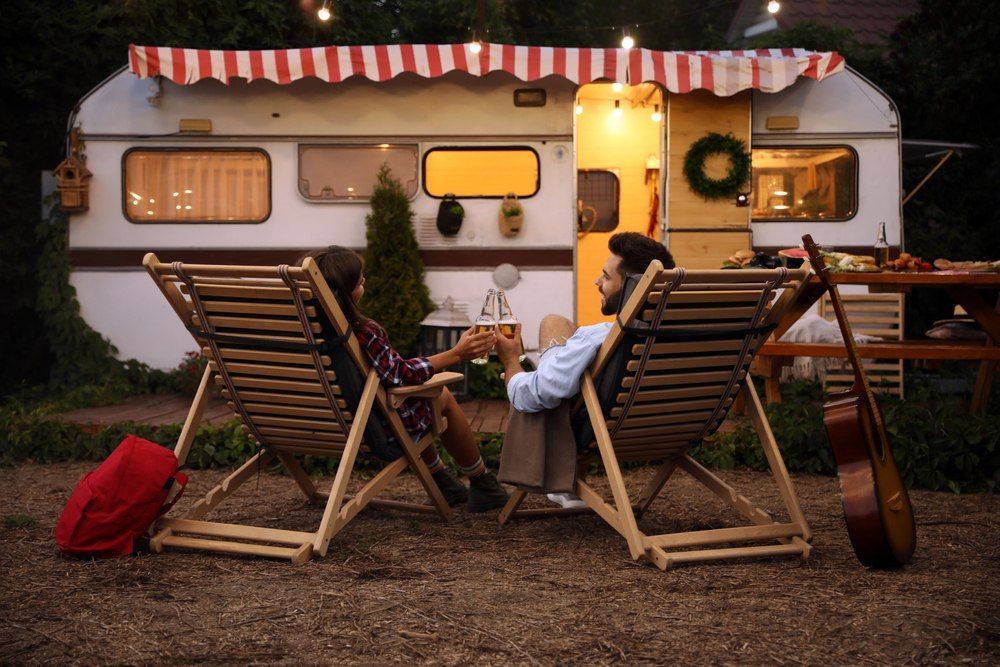 Couple Relaxing In Folding Chairs By A Vintage Trailer — Canobolas Canvas In Orange, NSW