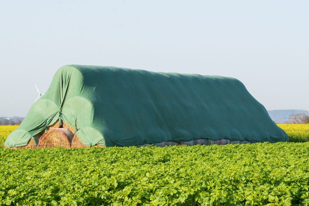 Hay Bales Covered With Green Tarp in a Field — Canobolas Canvas In Orange, NSW