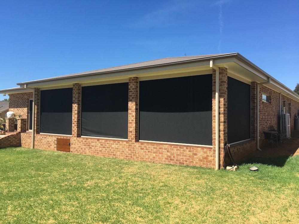 Brick Home with Three Black Outdoor Shades Lowered on a Sunny day — Canobolas Canvas in Orange, NSW