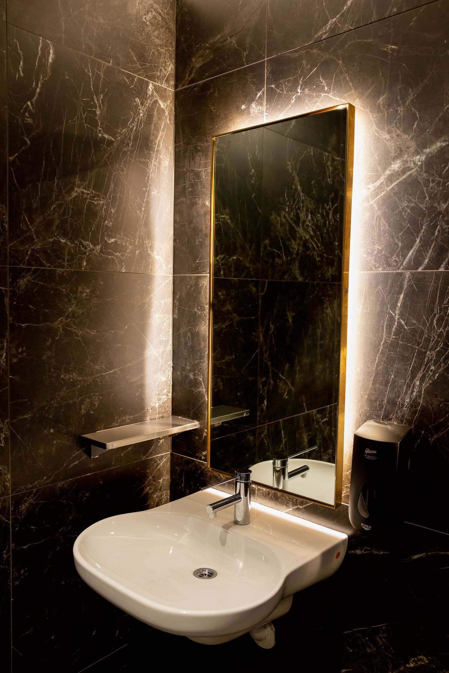 A bathroom with a sink and a mirror.