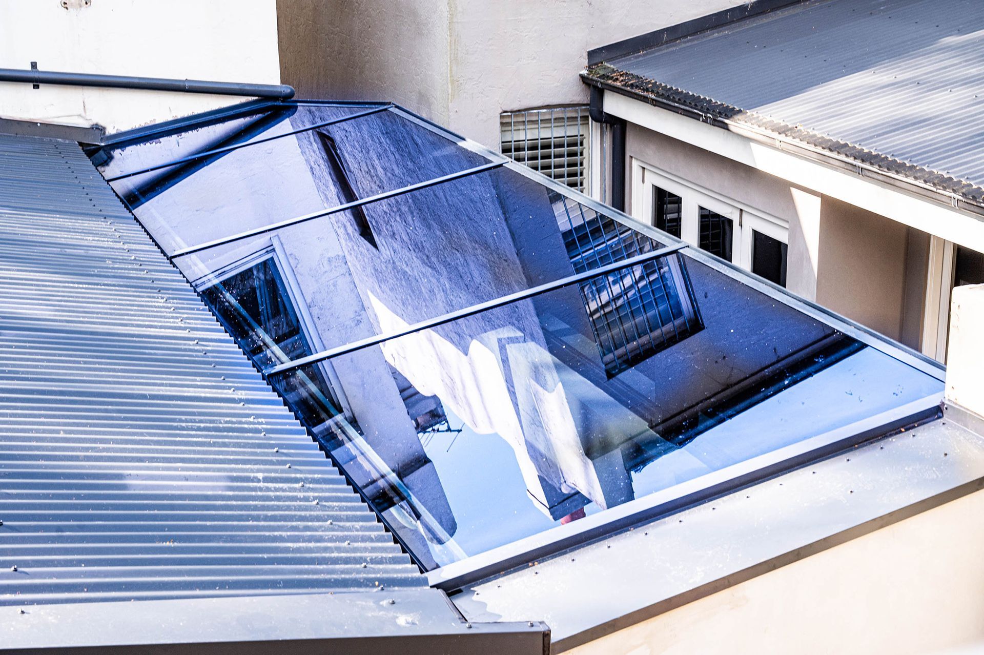 A roof with a reflection of a building in it.